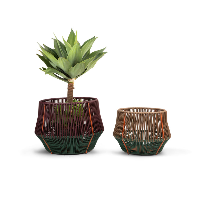 Displayed on a white background, the Ames Caribe Chic Basket 2 set includes two geometric planters with a woven design. The larger one, made from recycled plastic strings, holds an agave plant; the smaller features beige, green, and orange tones with mamposino braiding.