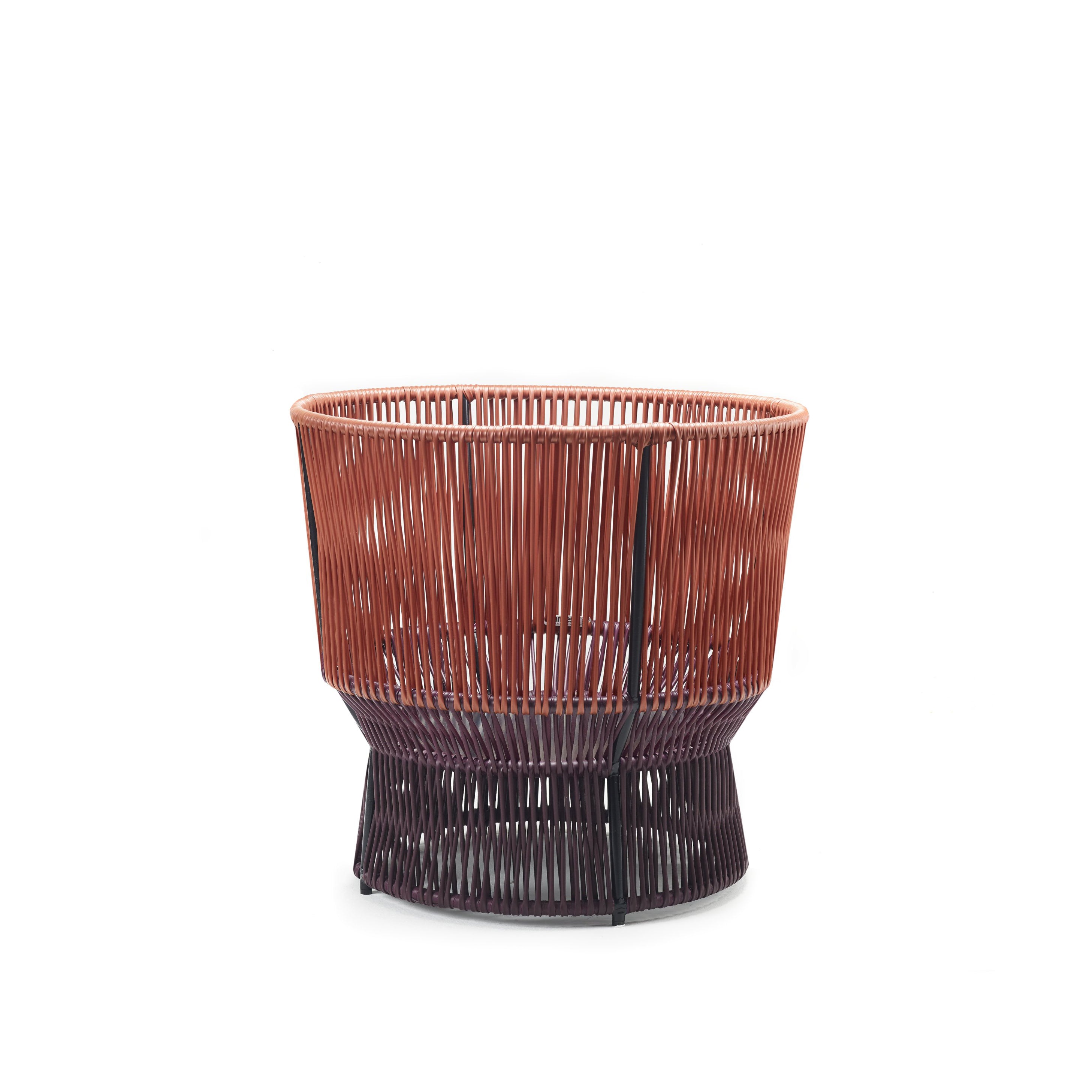 The Caribe Chic Basket 1 by Ames is a stylish, modern basket made using the mamposino braiding technique with red and dark brown recycled plastic strings. It features a striking two-tone design, open-top, and sturdy base for practicality and style.
