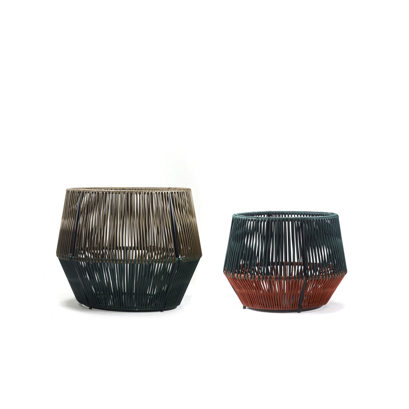 Two geometric Caribe Chic Basket 2 by Ames on a white background. The larger basket has dark green and brown hues, and the smaller one has dark green and rust orange tones. Both feature an angular design with vertical slats made from recycled plastic using the mamposino braiding technique.