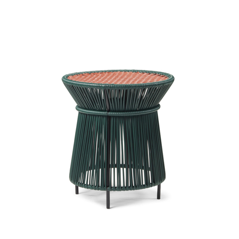 Explore the Caribe Chic High Table by Ames, designed by Sebastian Herkner. This modern piece features a round wicker top, an open green frame that flares outward, and black legs. Handcrafted in Colombia, it combines contemporary style with rustic charm.