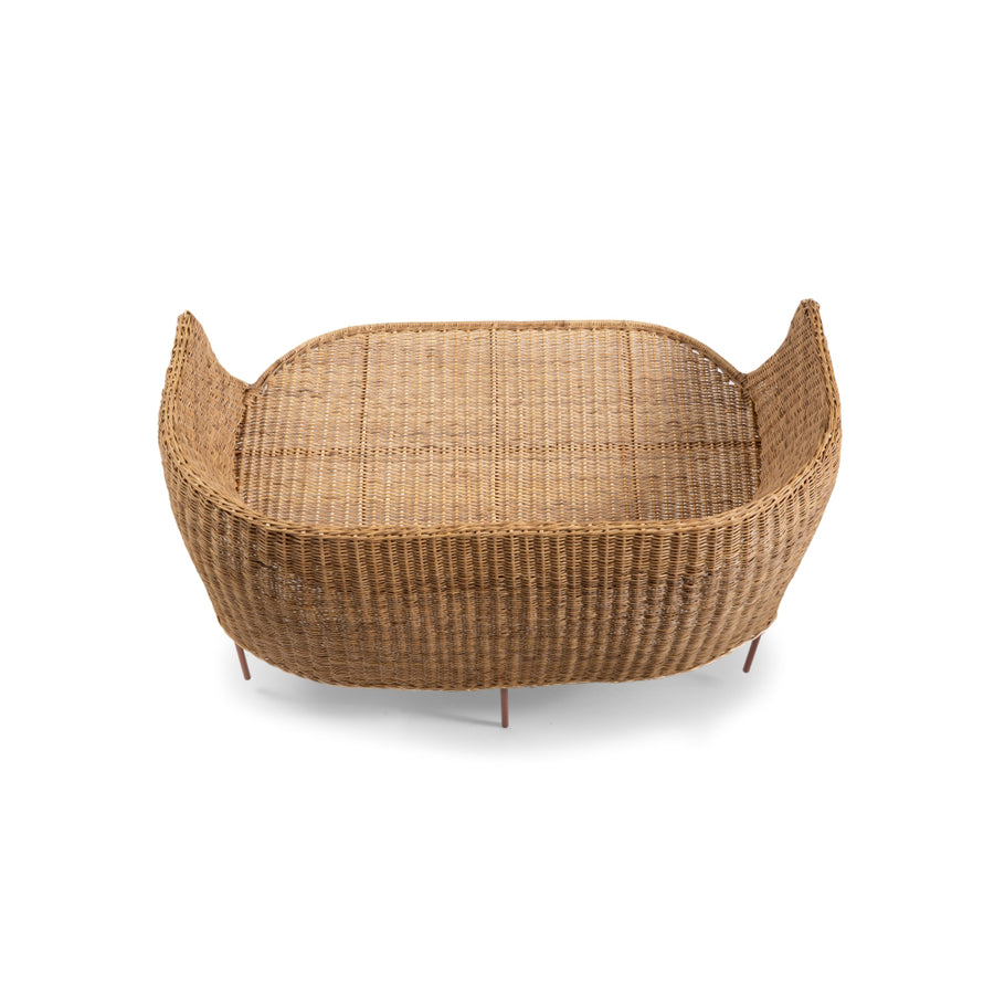 The Ames Caribe Natural Sofa boasts a rectangular, wicker basket design with high sides and an open top. It showcases Colombian craftsmanship with slightly curved corners and a woven texture, set against a white background.