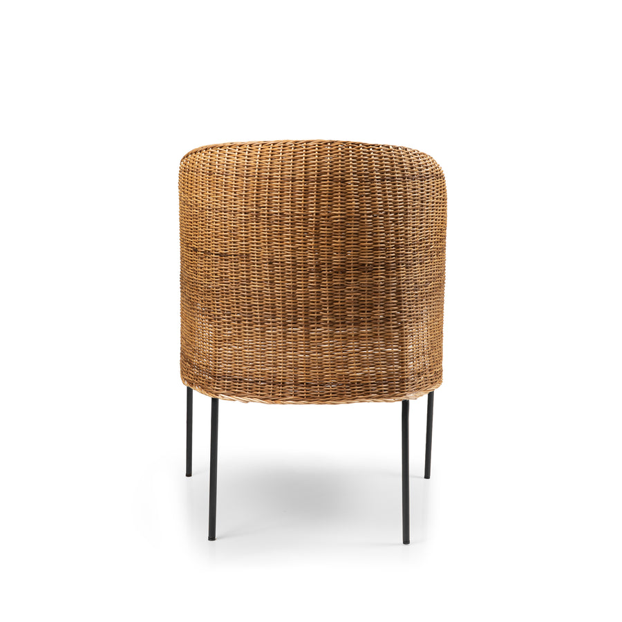 The Ames Caribe Natural Dining Chair by Ames showcases Colombian craftsmanship with a rounded wicker backrest and four slim black metal legs, displayed from the back against a plain white background.