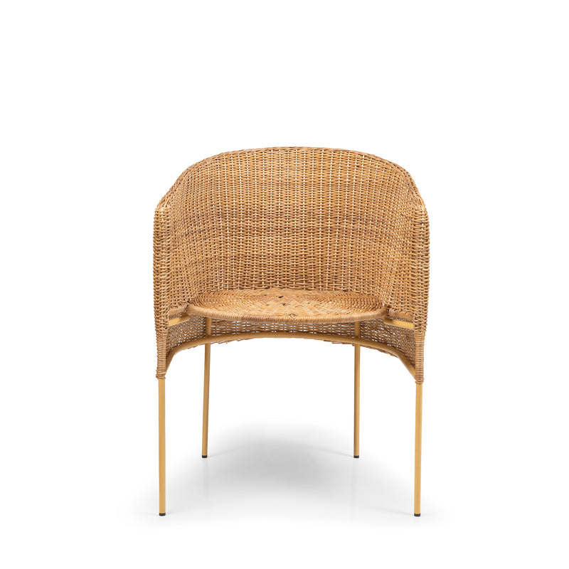 The Ames Caribe Natural Dining Chair by Ames features a rounded wicker backrest and seat on four slim gold metal legs, showcasing Colombian craftsmanship in natural wicker, set against a plain white background.