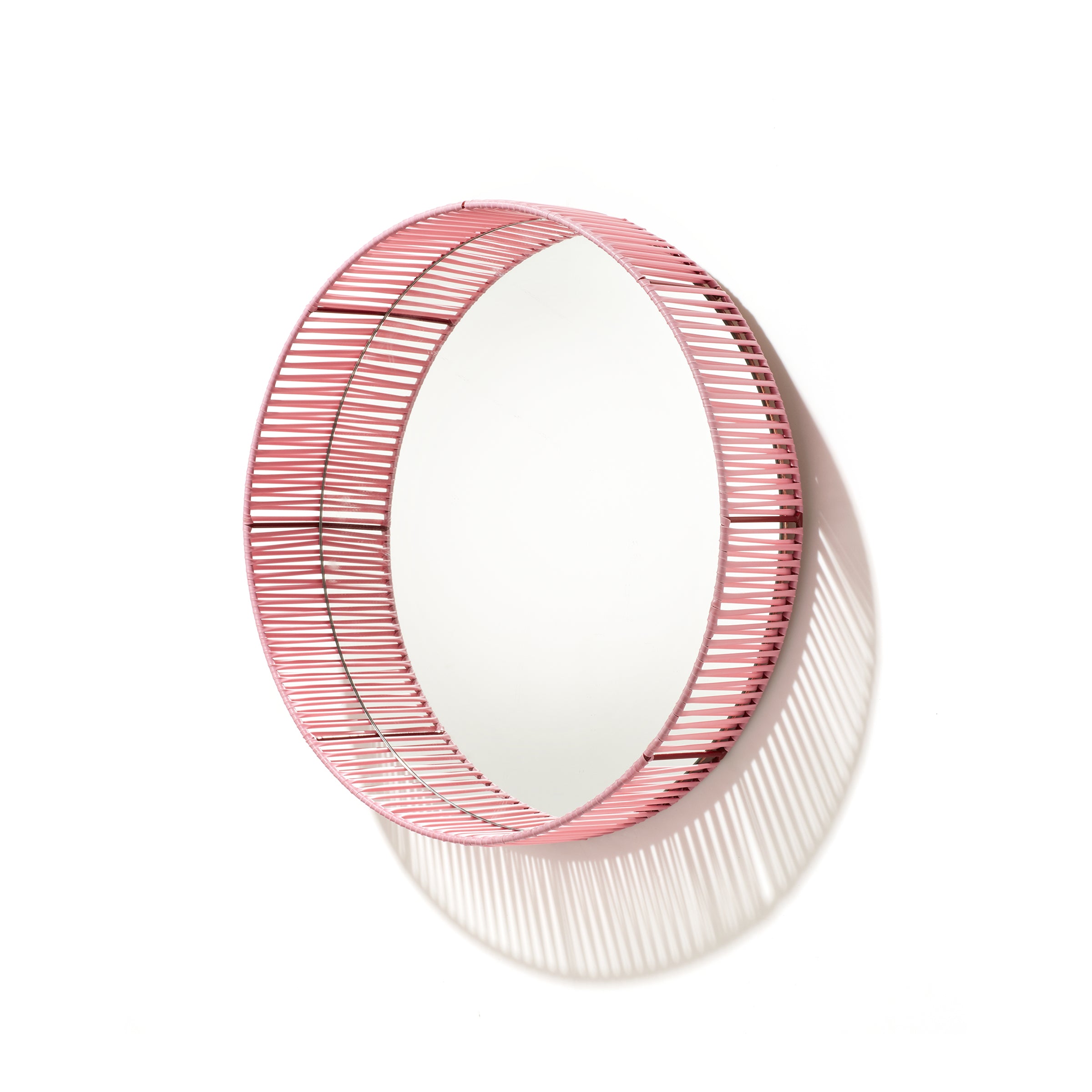 The Cesta Mirror by Ames is a round wall mirror featuring a unique pink wireframe border, casting striped shadows on its white background. Its vibrant color combinations create a striking visual effect, adding style to any room.