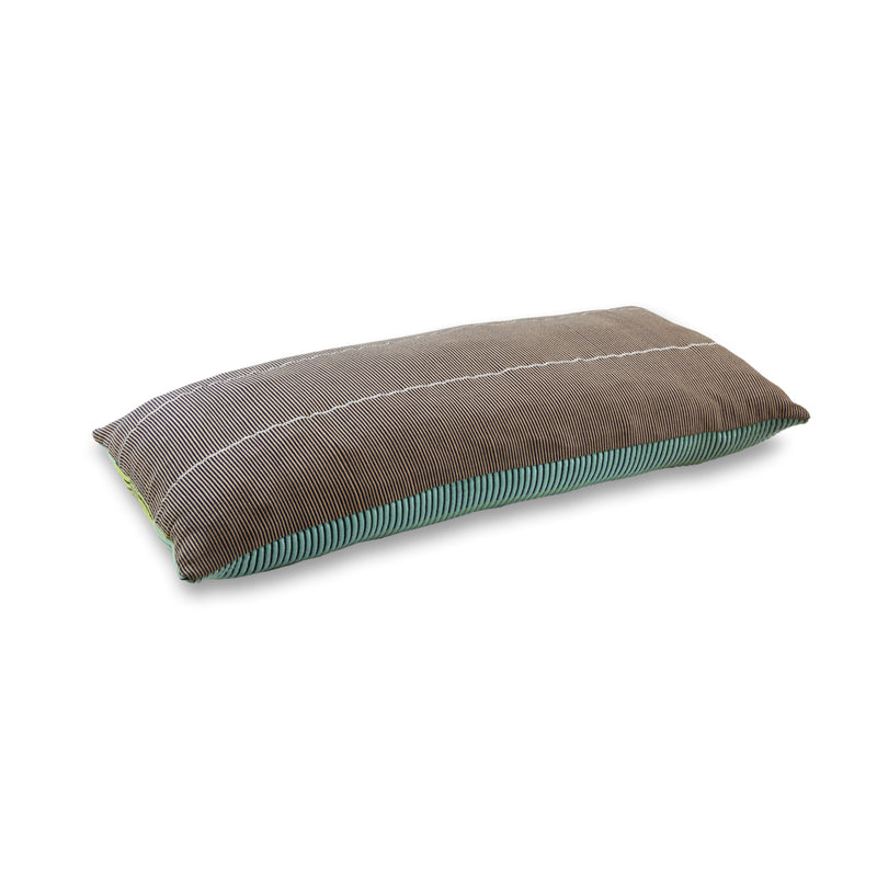 From the Chumbe collection by Ames, the Chumbes Layer is a long, rectangular pillow with hand-woven charm, featuring gray and brown stripes. Its green bordered bottom enhances its textured fabric, making it a standout among hand-woven cushions.