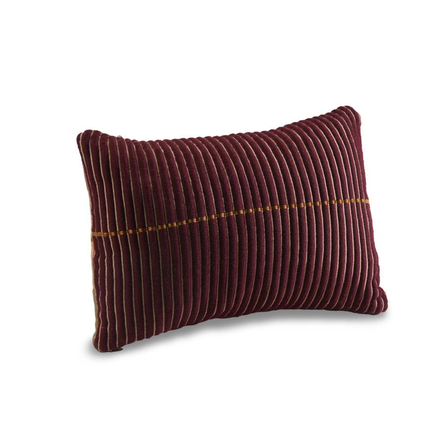 The Ames Chumbes Cushion by Ames is a rectangular maroon velvet pillow with vertical ridges and a center line of small golden beads, inspired by the Chumbes collection and set against a white background.
