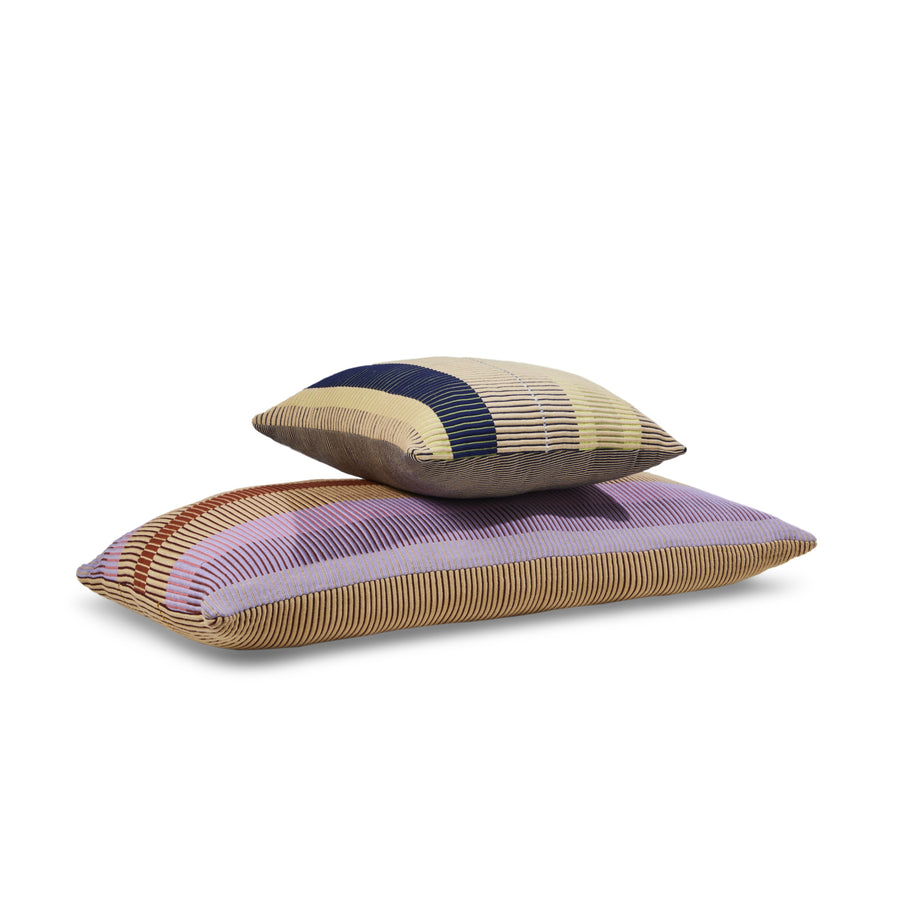 Two Ames Chumbes Cushions by Ames, hand-woven with textured fabric and horizontal stripes in beige, brown, purple, red, blue, and yellow, are stacked together.