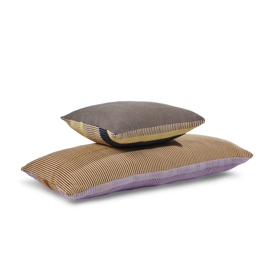 Two rectangular Ames Chumbes Cushions by Ames, hand-woven with fine stripes in brown, beige, yellow, purple, and black, designed by Mae Engelgeer, stacked against a plain white background.