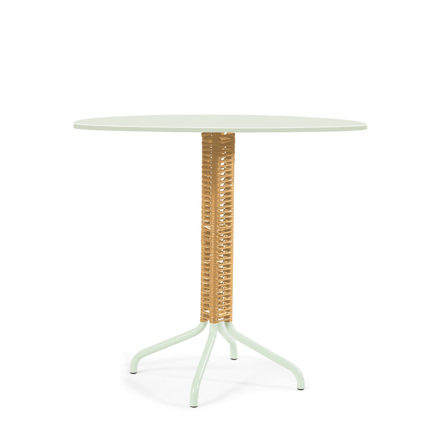 The Cielo Bistro Table by Ames is a round, slender piece designed by Sebastian Herkner. It features a light green wicker-wrapped central pole and four curved legs, perfect for compact indoor and outdoor settings.