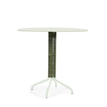 The Cielo Bistro Table by Ames, designed by Sebastian Herkner, showcases a round, pale green top and a textured cylindrical support with four slim, splayed legs, offering a modern aesthetic perfect as a bar or accent table.