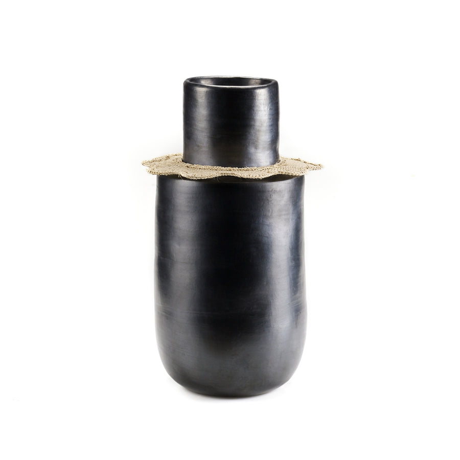 The Ames Coyar Vase 3 by Ames is a tall, matte black ceramic vase with a cylindrical neck, rounded body, and a light wickerwork band around the top, set against a plain white background.