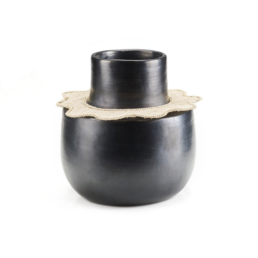 The Coyar Vase 4 by Ames is an exquisite black ceramic piece with a wide base and narrow neck, adorned with a textured beige ruffle reminiscent of wickerwork. Its set against a plain white background.
