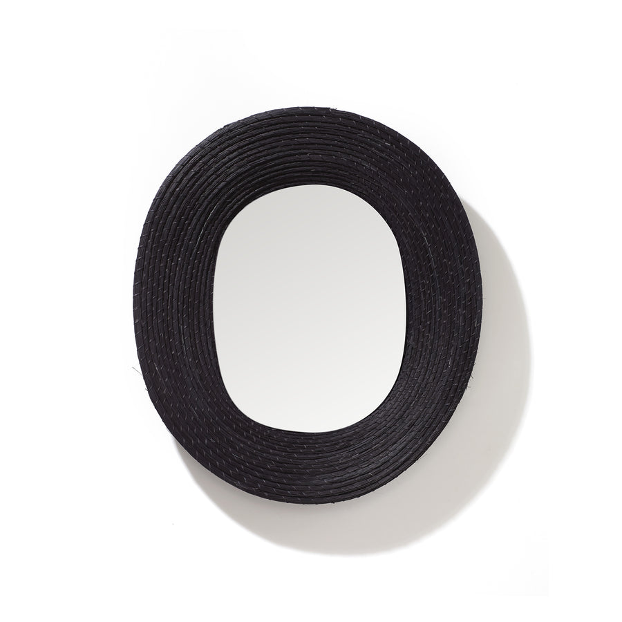 The Ames Killa Mirror by Ames is a round wall mirror featuring a thick, textured black frame handmade from Iraca palm, shown against a plain white background.