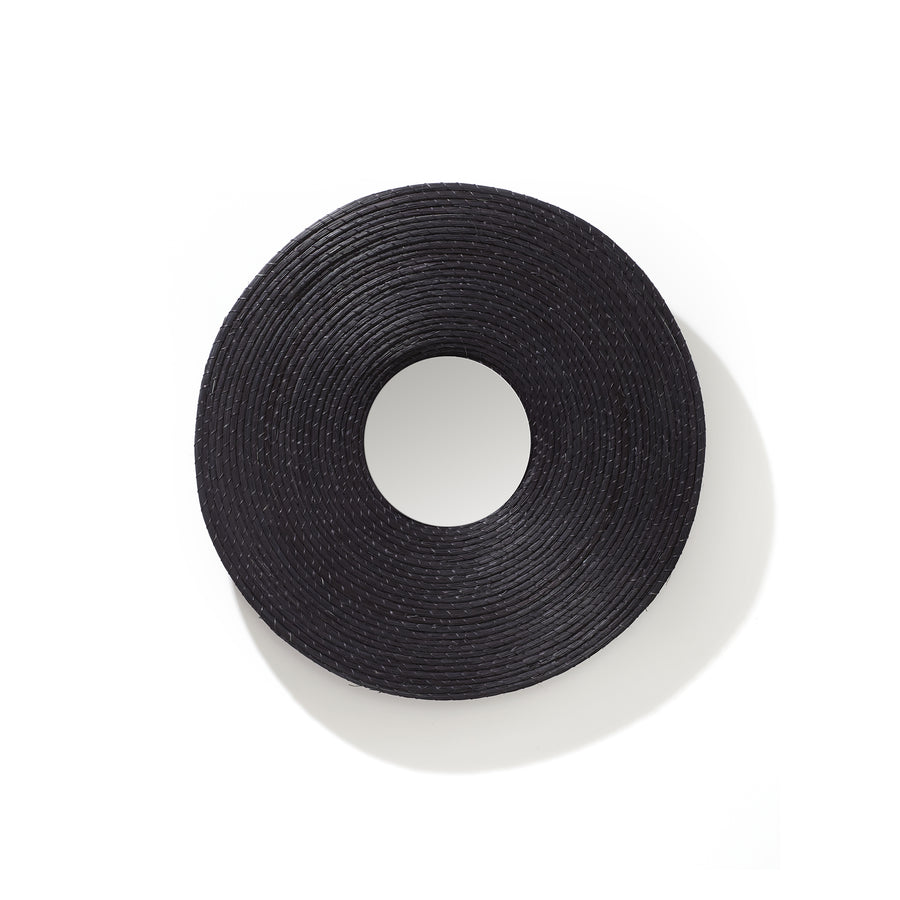 The Ames Killa Mirror by Ames, featuring a black, round, flat woven Iraca palm frame with a wide brim, is displayed on a white background and viewed from above.