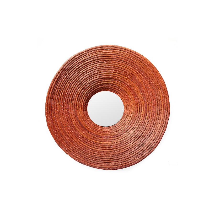 The Ames Killa Mirror by Ames features a round design with a thick, textured, reddish-brown woven frame that resembles coiled Iraca palm rope, shown against a white background.