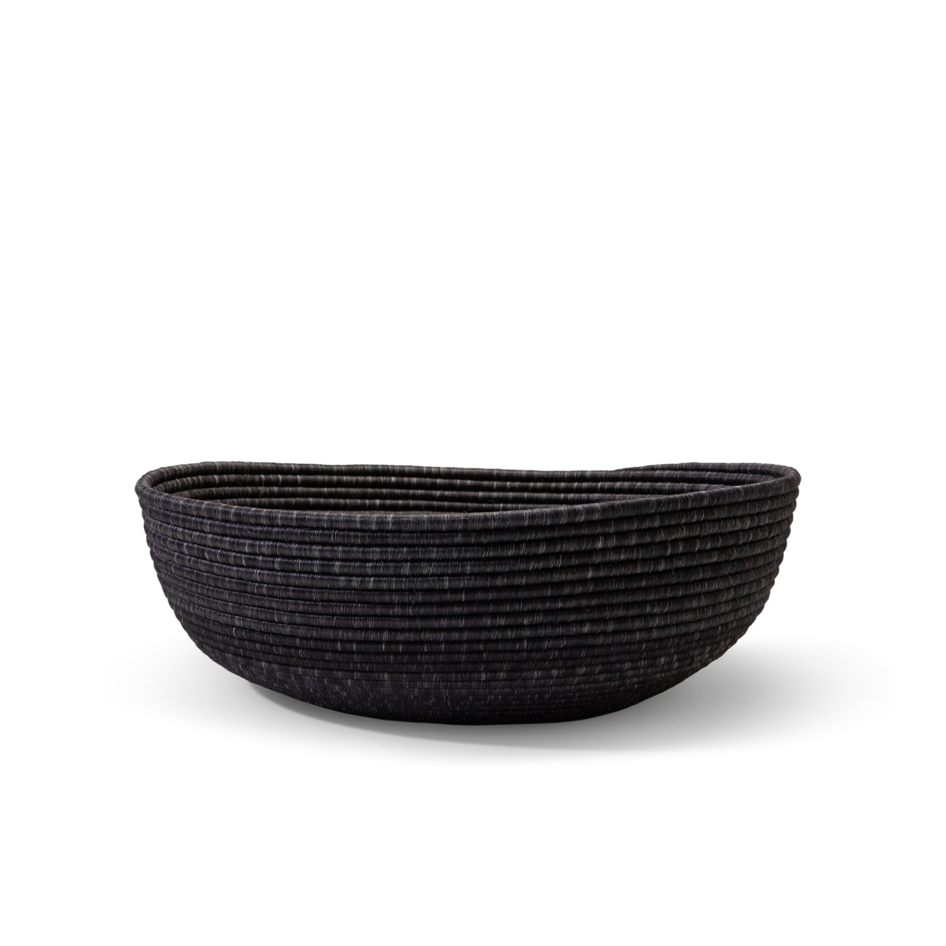 The Ames La Che Basket by Ames is a wide, shallow black basket made of textured Fique fibers, shown against a white background.