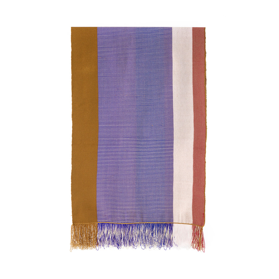 The Maraca Hammock by Ames features a rectangular fabric with vertical stripes in gold, purple, white, and red. It evokes the ethnic designs of Colombian hammocks with fringed edges matching these colors, delicate patterns throughout, and a plain white background.