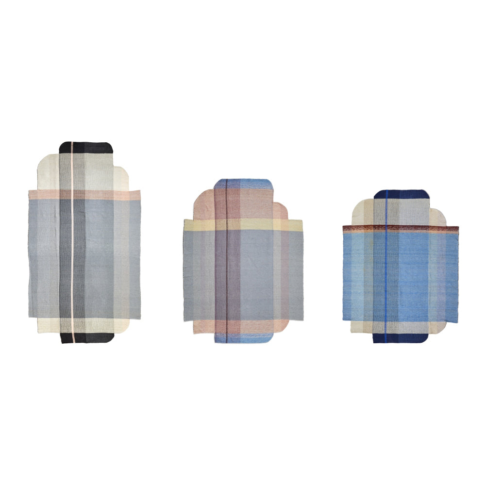 Three abstract Ames Muyska Rugs by Ames, each rectangular with rounded corners, feature layered translucent fabrics in pastel and blue hues. Displayed side by side on a white background, they evoke a modern, designer aesthetic.