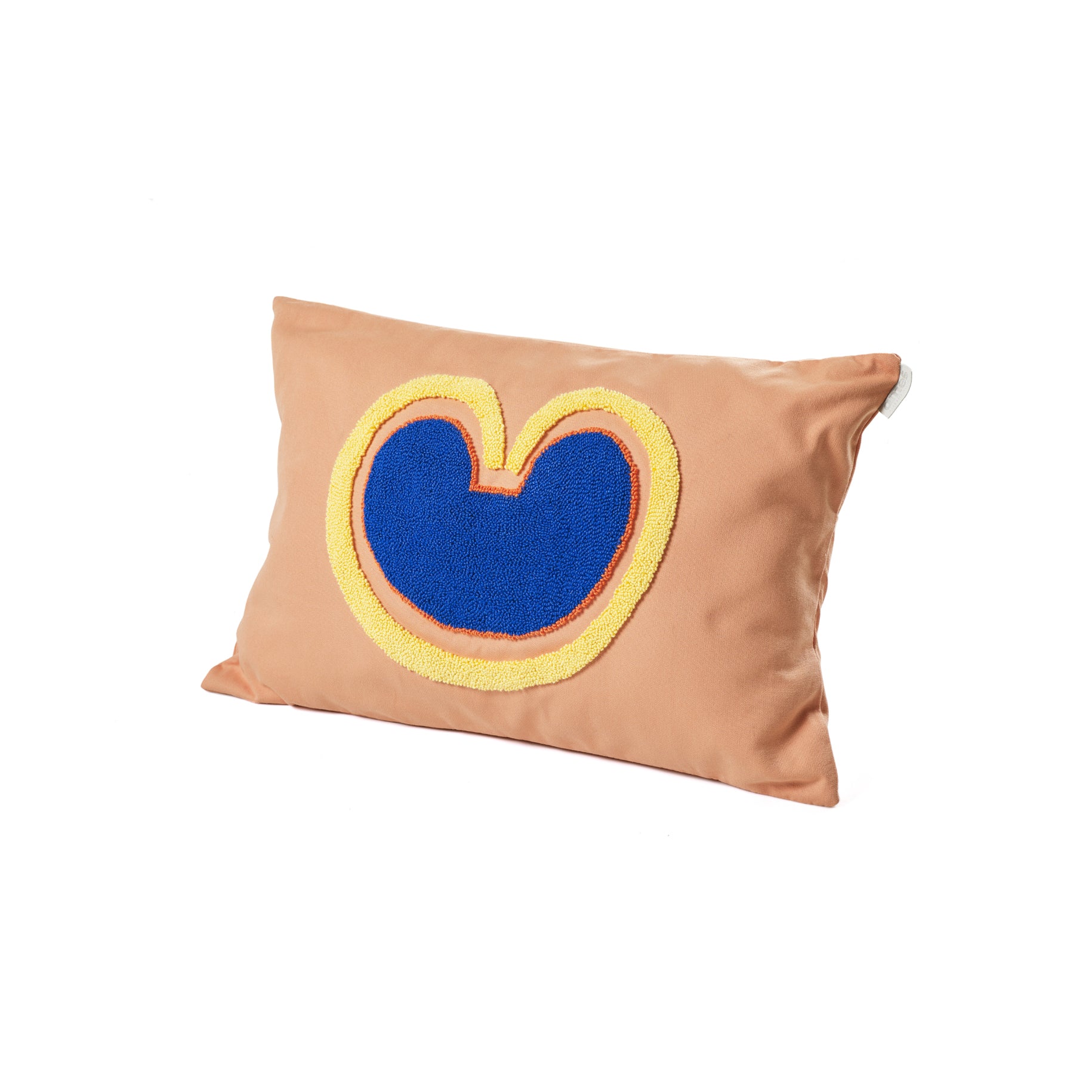 The Ames Nido Coraz pillow by Ames is rectangular and tan, featuring a blue heart-shaped abstract design outlined in yellow on a white background.