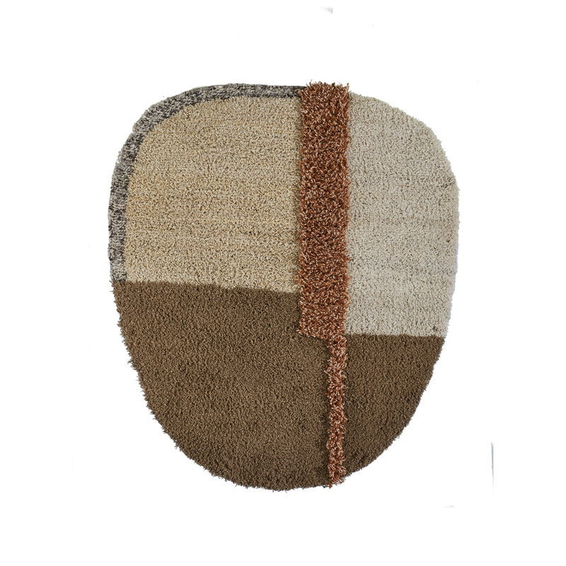 The Nudo Rug by Ames is an oval-shaped textured wall hanging inspired by Colombian arts and crafts, featuring sections in beige, light brown, and dark brown with a vertical orange strip for contrast.