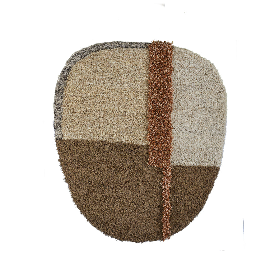 The Nudo Rug by Ames is an oval-shaped textured wall hanging inspired by Colombian arts and crafts, featuring sections in beige, light brown, and dark brown with a vertical orange strip for contrast.