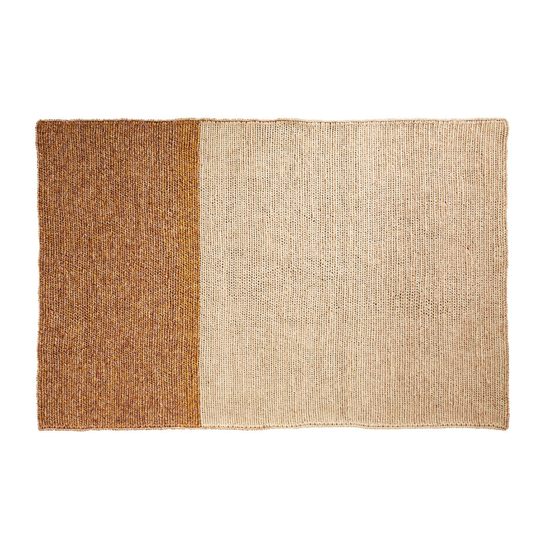 The Ames Par Rug by Ames is a rectangular woven rug made from the fique plant, with a textured knit-like look and two color blocks: brown on the left and a larger beige section on the right.