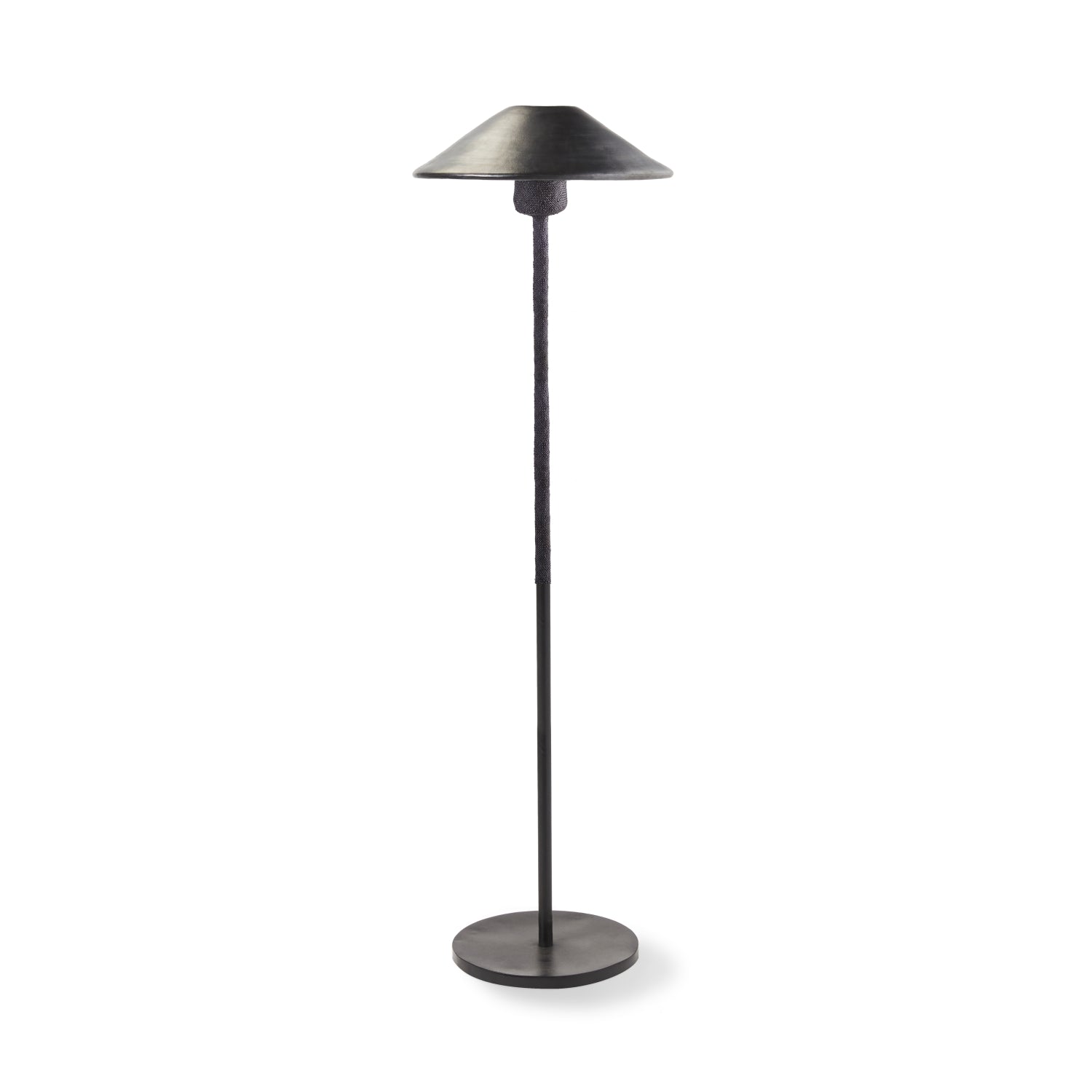 The Ames Raiz Floor Lamp by Ames features a black metal finish, slender pole, and wide cone-shaped shade. Its minimalistic, modern design complements handmade ceramic pendant lights inspired by Colombian craftsmanship.