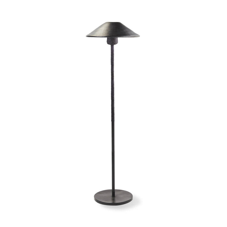 The Ames Raiz Floor Lamp by Ames features a black metal finish, slender pole, and wide cone-shaped shade. Its minimalistic, modern design complements handmade ceramic pendant lights inspired by Colombian craftsmanship.
