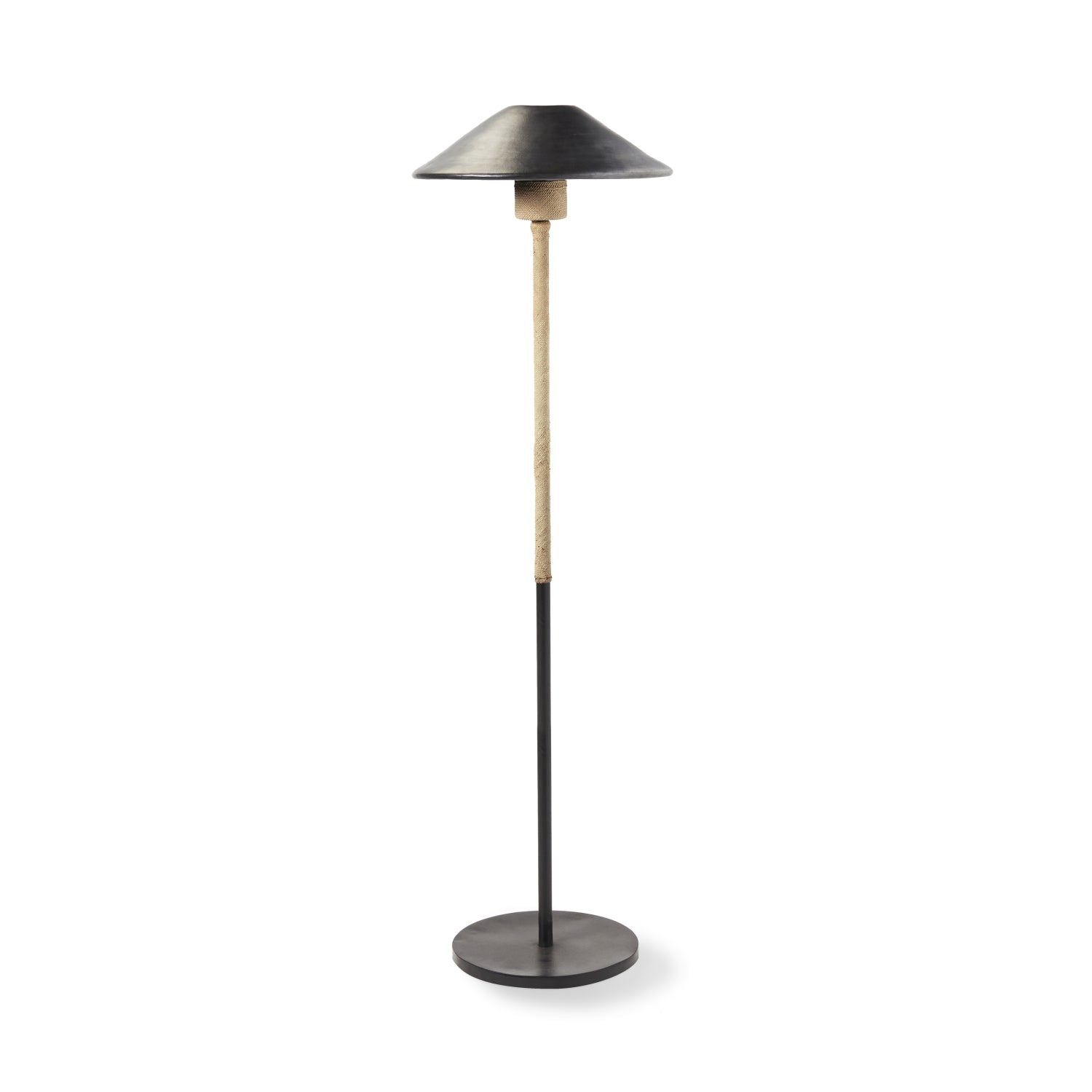 The Ames Raiz Floor Lamp by Ames features a round black base, a slim black and wood pole, and a wide, shallow black lampshade inspired by Colombian craftsmanship.