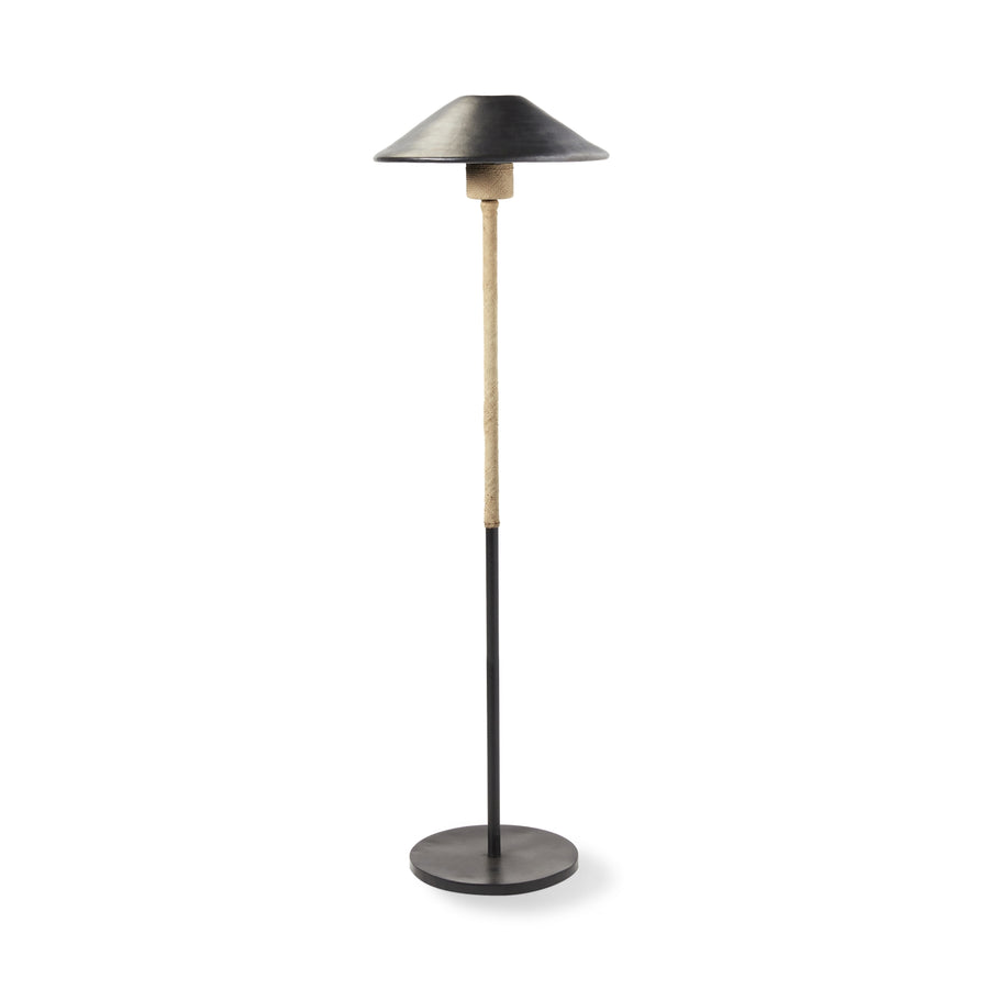 The Ames Raiz Floor Lamp by Ames features a round black base, a slim black and wood pole, and a wide, shallow black lampshade inspired by Colombian craftsmanship.