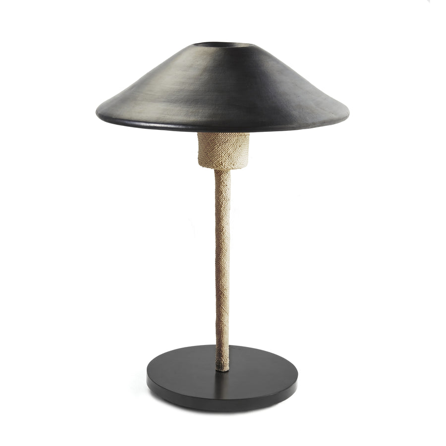 The Raiz Table Lamp by Ames features a modern design with a wide black conical shade, textured light-colored stem, and round black base. Its minimalistic style is enriched with Colombian craftsmanship for a sleek and contemporary look.