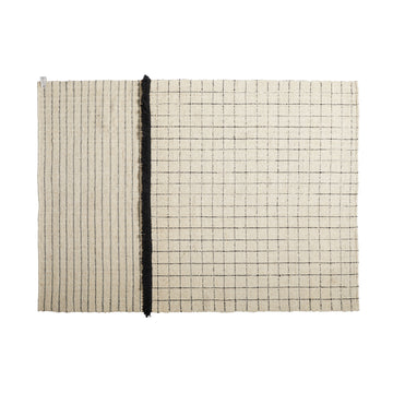 The Ames Subas Rug by Ames is a rectangular beige wool rug featuring thin black stripes on the left, a grid pattern on the right, and a bold vertical black dividing line.