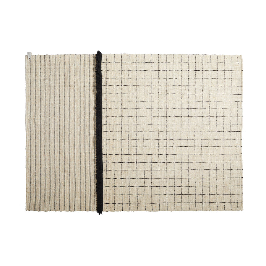 The Ames Subas Rug by Ames is a rectangular beige wool rug featuring thin black stripes on the left, a grid pattern on the right, and a bold vertical black dividing line.