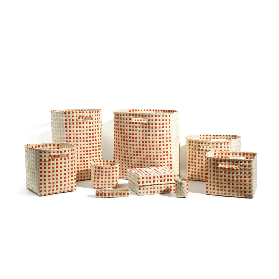 The Suncho Baskets by Ames, designed by Pauline Deltour, are a hand-made collection of storage options in various sizes. Crafted from recycled Polypropylene, these baskets feature an orange and white checkered pattern and come in both rectangular and cylindrical shapes.