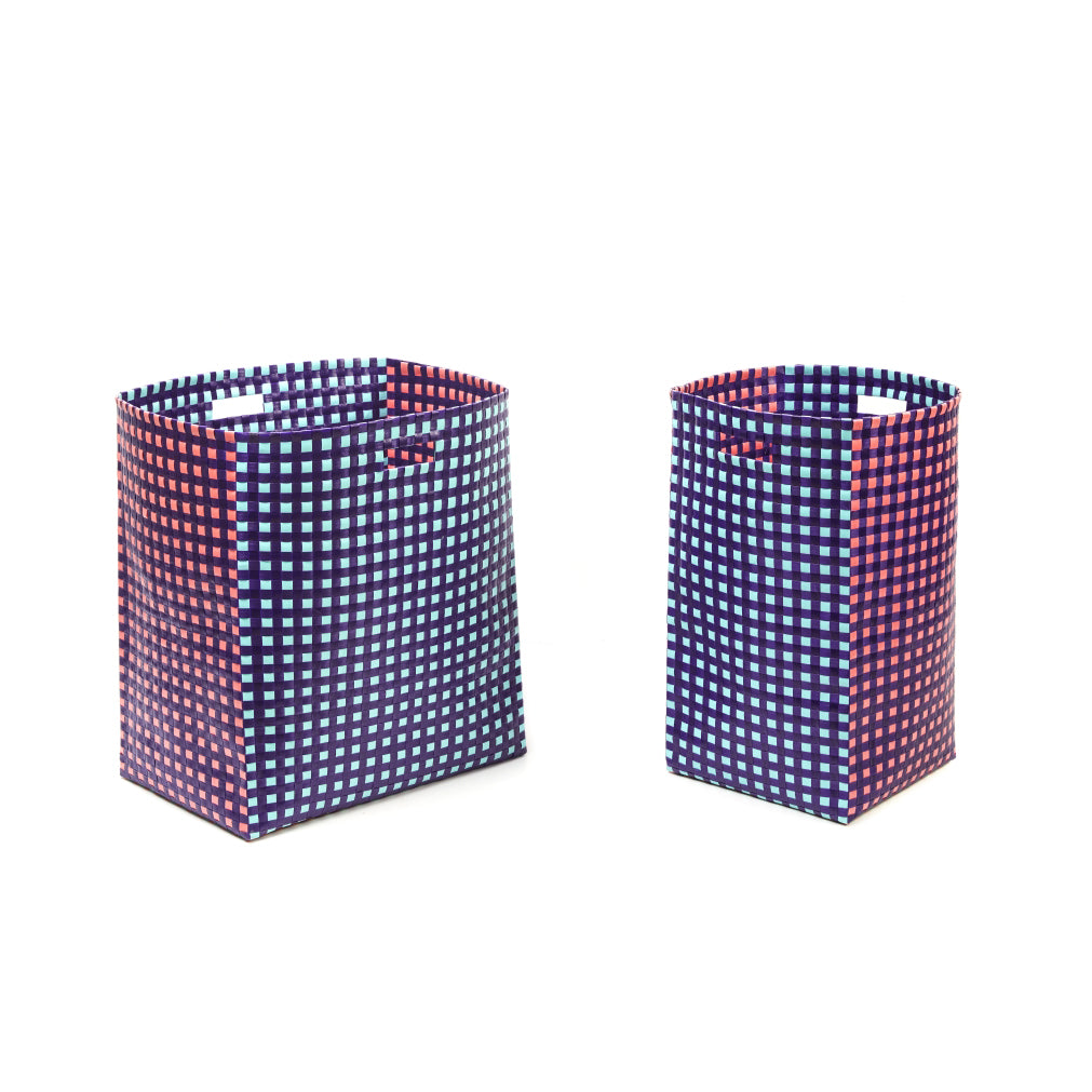 Two rectangular Suncho Baskets, a large and a small one, from Ames feature red and blue checkered patterns on a white background. Hand-made with open tops and side handles, these sustainable baskets are crafted from recycled polypropylene for style and convenience.