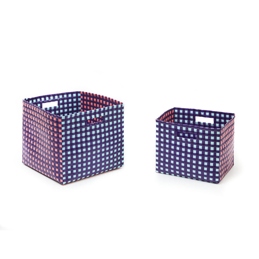 The Suncho Baskets by Ames, made from recycled polypropylene, are two square storage solutions in a blue, red, and white checkered pattern. They feature side cut-out handles. The larger basket is on the left and the smaller on the right against a plain white background.