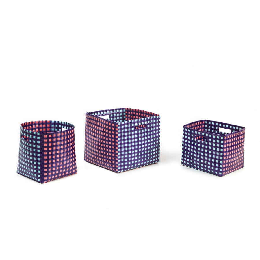 Three Suncho Baskets by Ames, featuring checkered patterns in navy blue, pink, and white are arranged in a row. Handcrafted from recycled polypropylene, these baskets range from small to large and offer woven textures with handles for easy carrying.