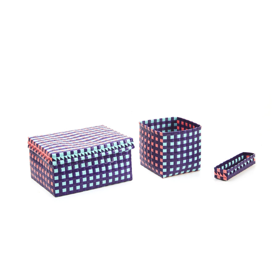 Three hand-made Suncho Baskets from Ames come in varied sizes: a lidded rectangular box, an open square basket, and a flat rectangular basket. Crafted from recycled Polypropylene, they feature Pauline Deltours blue and red checkered design.