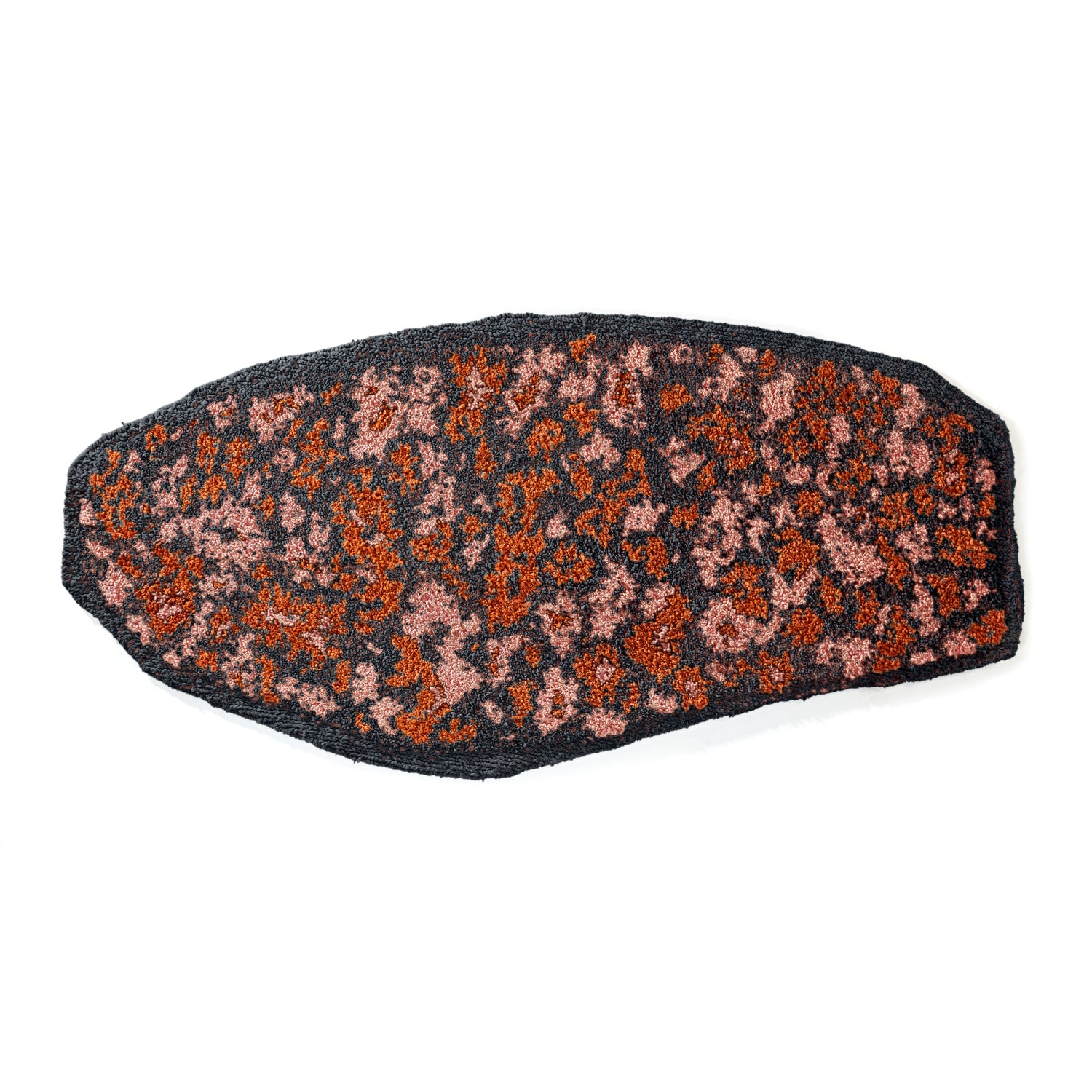 The Ames Zipa Rug by Ames is a black, irregular oval rug with a textured surface, designed by Sebastian Herkner. It features reddish and pinkish spots for a floral or speckled look that makes a colorful statement.