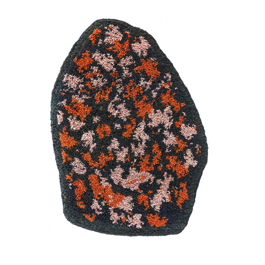 An irregularly shaped, textured rug with a dark base and scattered orange and pink patches, featuring an abstract pattern—much like the colorful Ames Zipa Rug by Ames.
