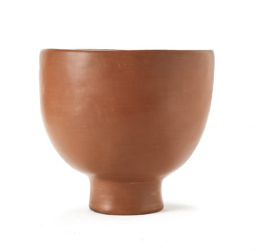 The Barro Pot 1 by Ames is a round, smooth, terracotta-colored ceramic pot with a wide body and narrow short base that stands elegantly against a plain white background.