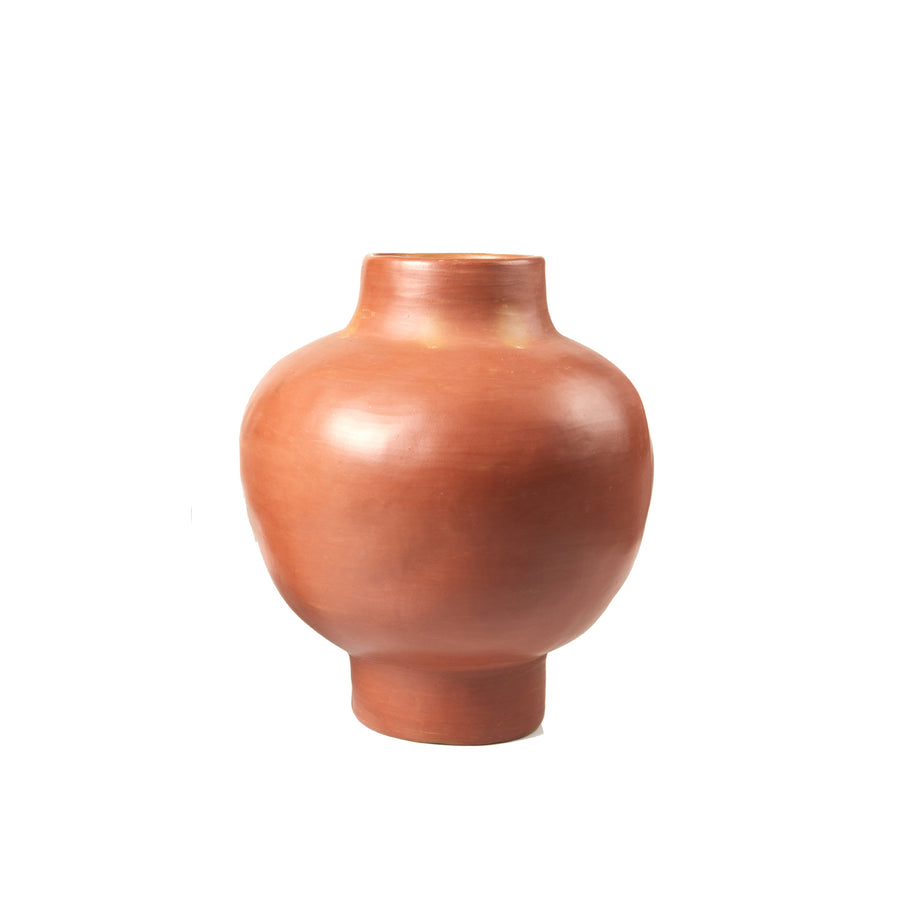 The Ames Barro Vase by Ames is a simple, round, reddish-brown ceramic vase with a narrow neck and base, inspired by handmade Colombian ceramics and shown against a white background.