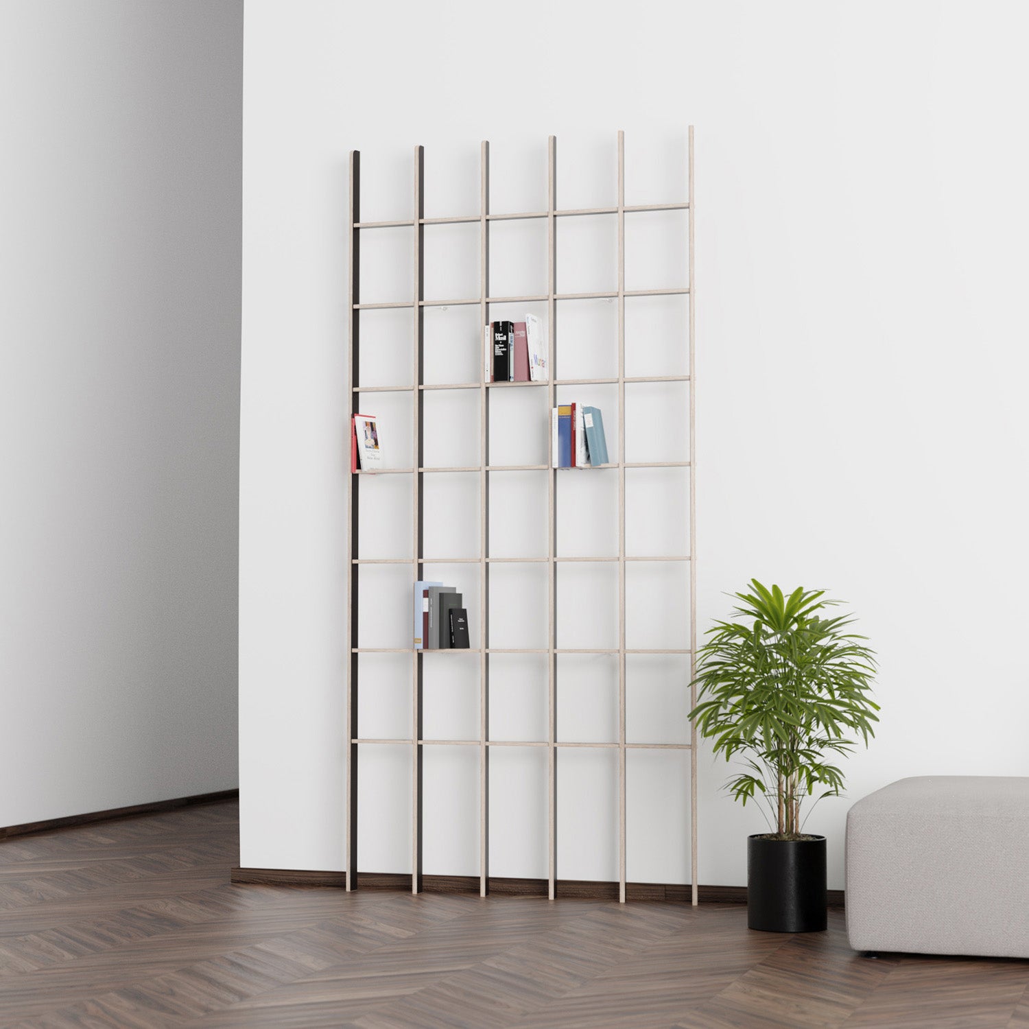 An Open bookcase by Martin Breuer Bono leans against a white wall with a few books. A potted plant adorns the dark wood floor nearby, and part of a gray sofa is visible on the right, completing the serene design aesthetic.