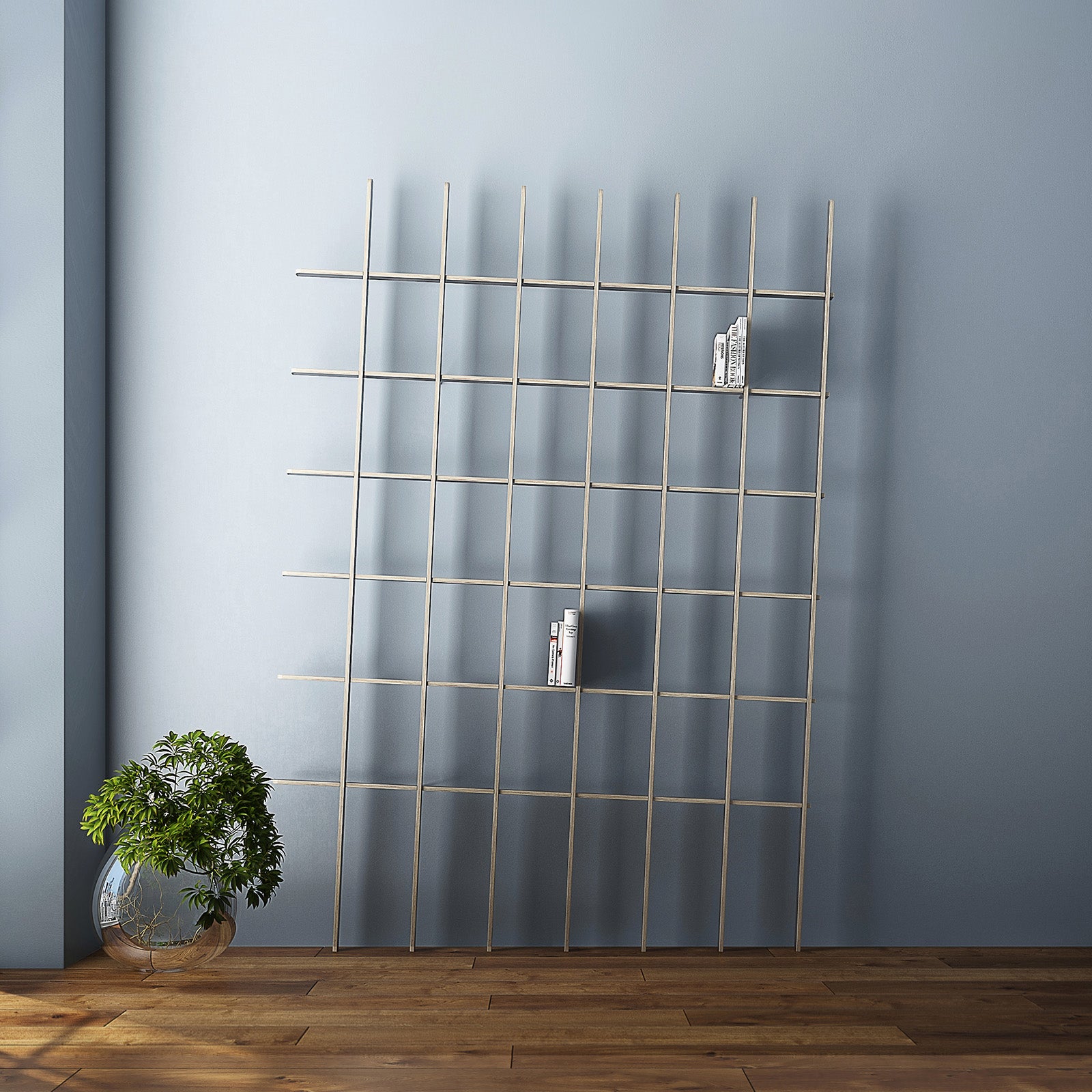 A sculptural minimalist room displays the SCHLAGSEITE grid-style metal bookshelf from Martin Breuer Bono, leaning against a light blue wall. Sparse books fill the shelves, complemented by a clear vase with green foliage on the wooden floor.
