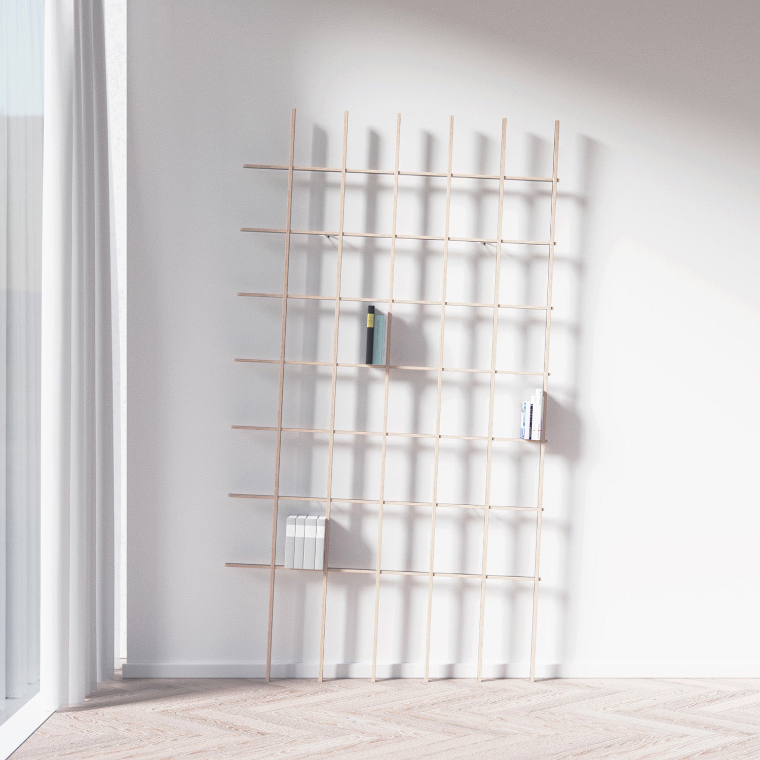 The SCHLAGSEITE bookshelf by Martin Breuer Bono features a sculptural, minimalist grid design. It leans against a white wall in a room with large windows and light wood flooring, creating a bright and airy atmosphere while holding a few books on its shelves.
