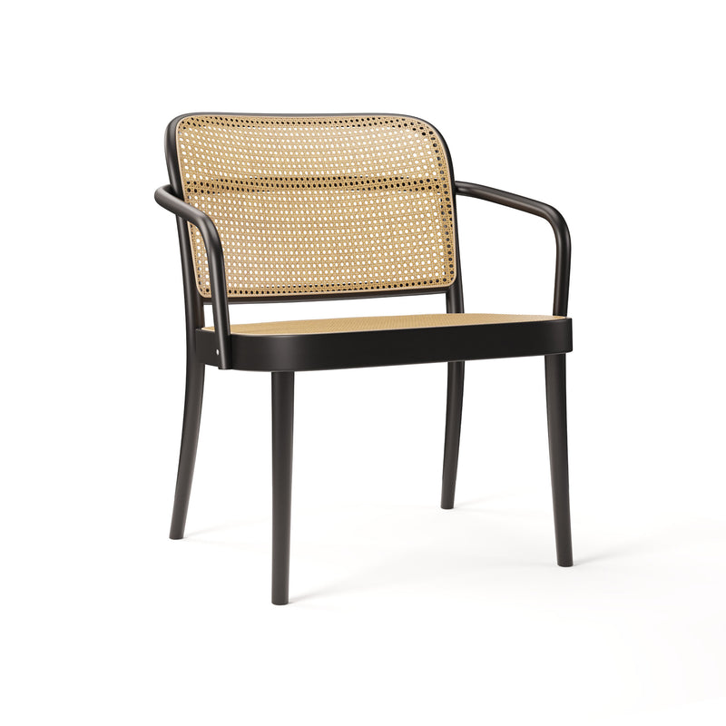 The Lounge Armchair 811 by TON is a modern piece featuring a black metal frame with armrests. Elegant cane weaves adorn the light tan woven backrest and seat, merging classic wicker style with contemporary design. It stands gracefully on four slender legs.