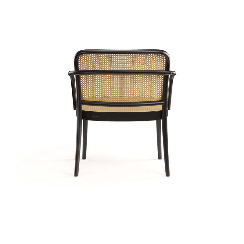 A back view of the Lounge Armchair 811 by TON, featuring black wood with intricate cane weaves on the seat and backrest. This four-legged chair has sleek armrests and a minimalist design, set against a white background.