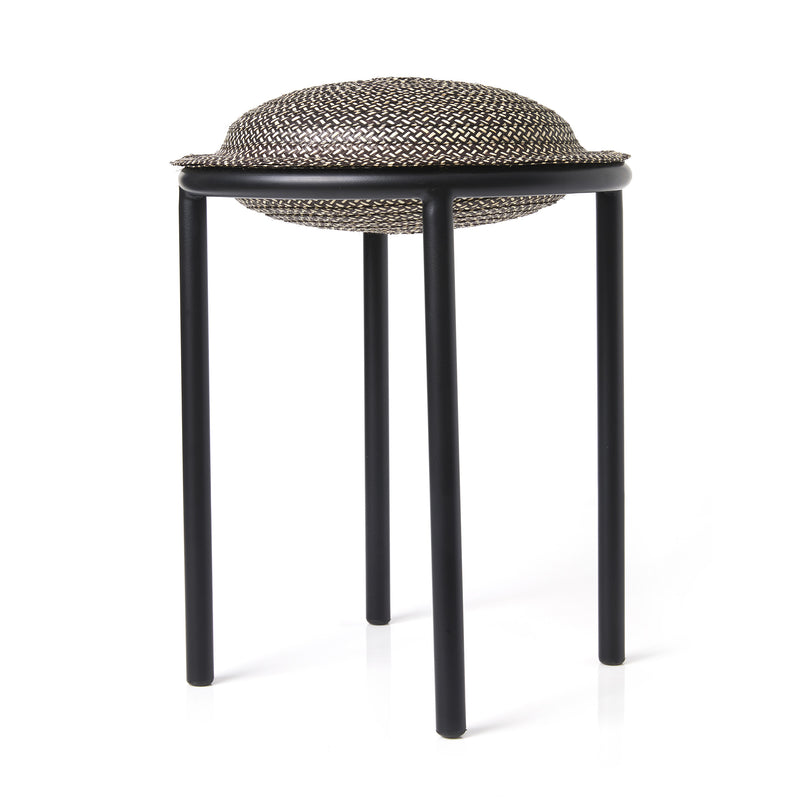 Introducing the Cana Stool by Ames: a modern and unique stool with a textured, round, woven seat like a large button. It stands on three slender black legs against a white background, featuring vibrant colors to enliven any space.