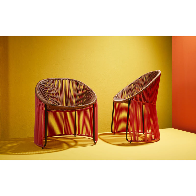Two Ames Cartagenas Dining Chairs by Ames, with circular woven red and yellow cord seats and backs, stand on a yellow floor against vibrant yellow and orange walls for a modern, minimalistic look.