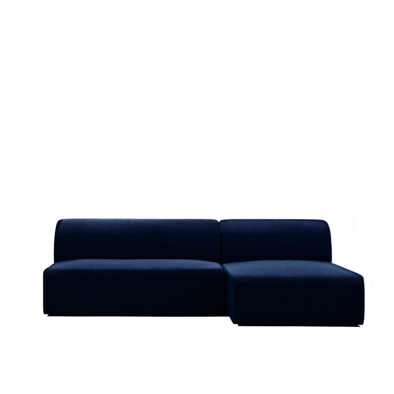 The Objekte unserer Tage Weber Modular Sofa is a sleek, dark blue sectional with a left-facing chaise lounge. Its smooth fabric and minimalistic design contrast elegantly against a white background, showcasing contemporary style and subtle German sensuality.
